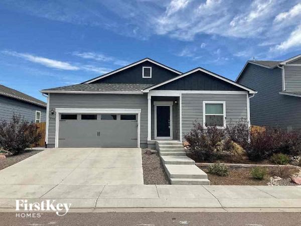 a gray house with a driveway and a garage door