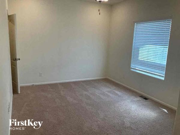 an empty room with a window and a carpet