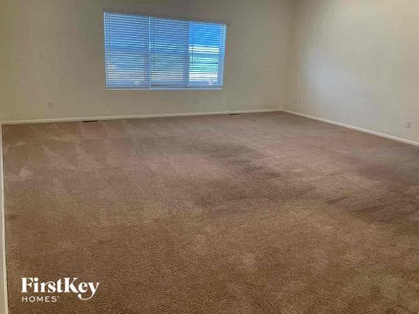 an empty room with a carpeted floor and a window