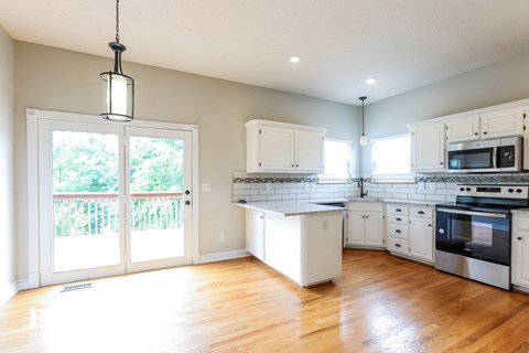 a kitchen with white cabinets and a wood floor