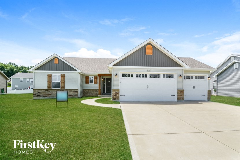 the front of a house with a driveway and a garage door
