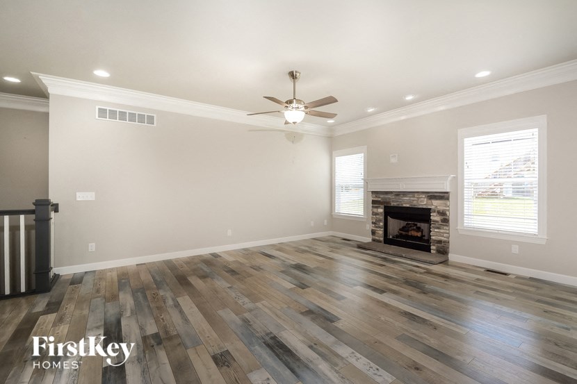 a living room with a fireplace and a ceiling fan