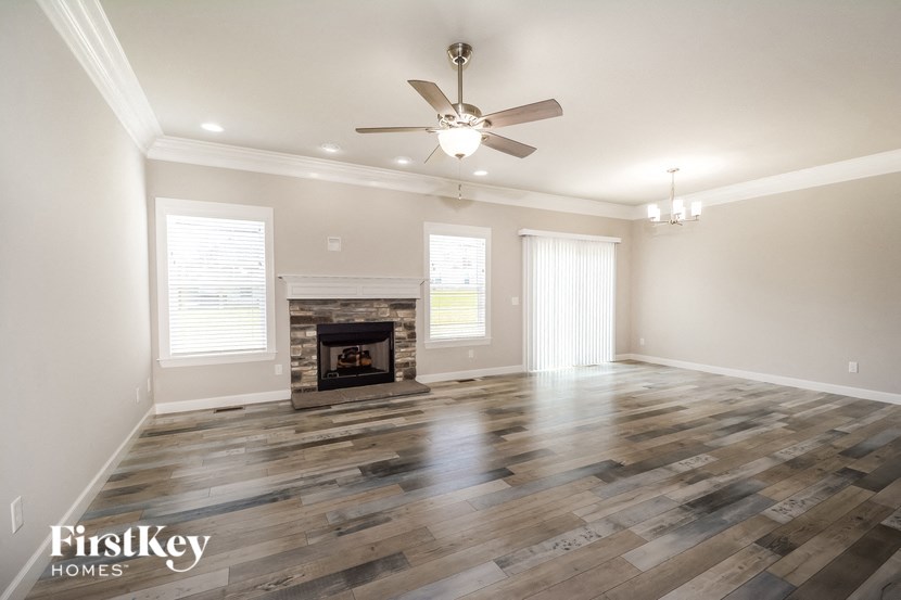 a living room with a fireplace and a ceiling fan