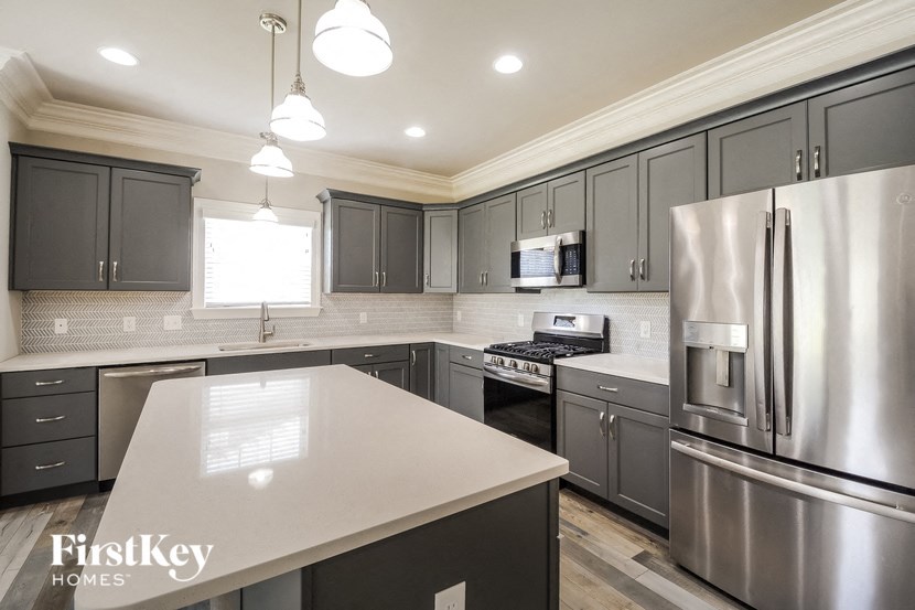 a kitchen with stainless steel appliances and white counter tops