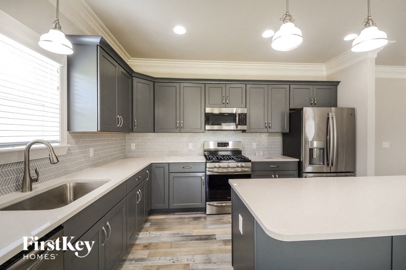 a kitchen with stainless steel appliances and gray cabinets