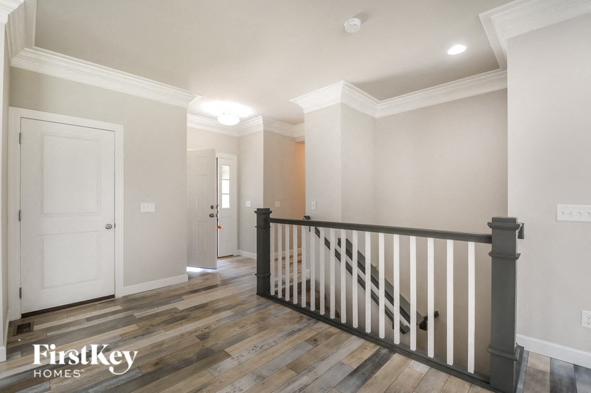 the landing of a staircase in a home with white walls and wood floors