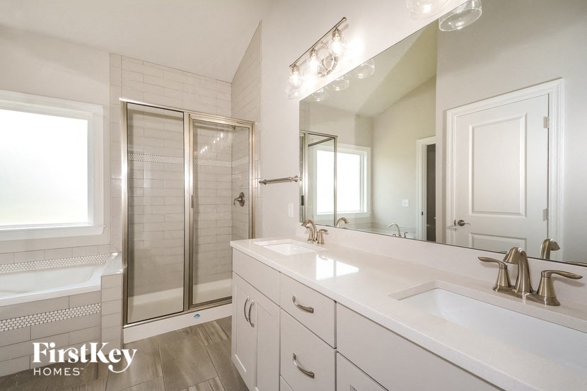 a white bathroom with two sinks and a shower