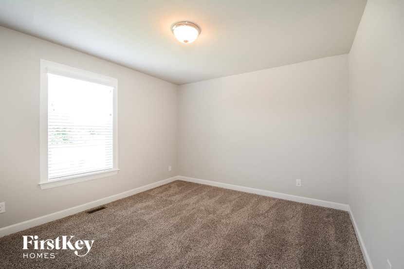 an empty room with carpet and a window