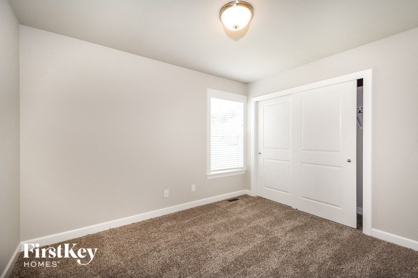 a bedroom with a carpeted floor and a white door