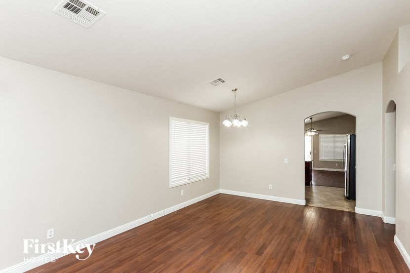 a living room with a hard wood floor and white walls