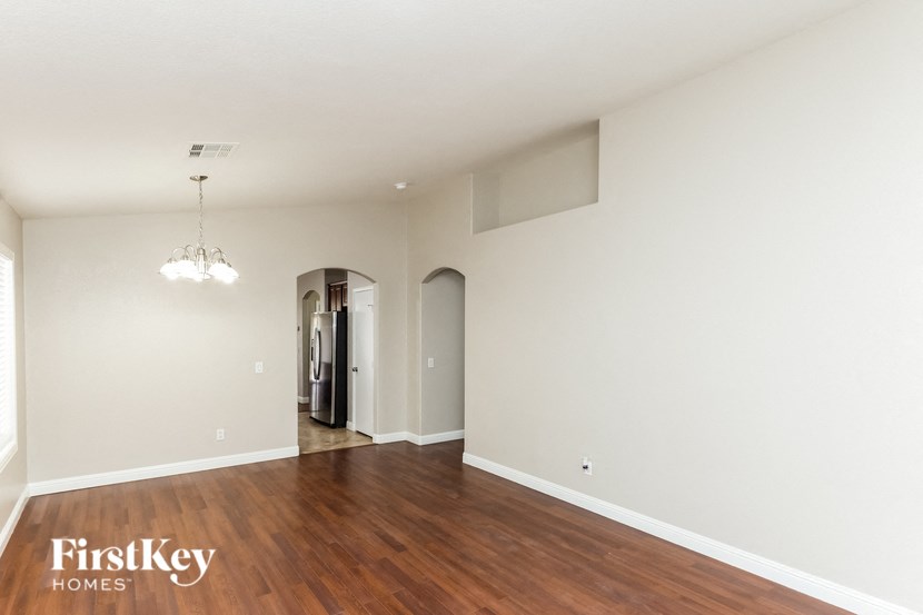 an empty living room with wood flooring and white walls