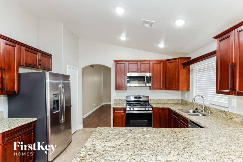 a kitchen with wood cabinets and granite counter tops and stainless steel appliances