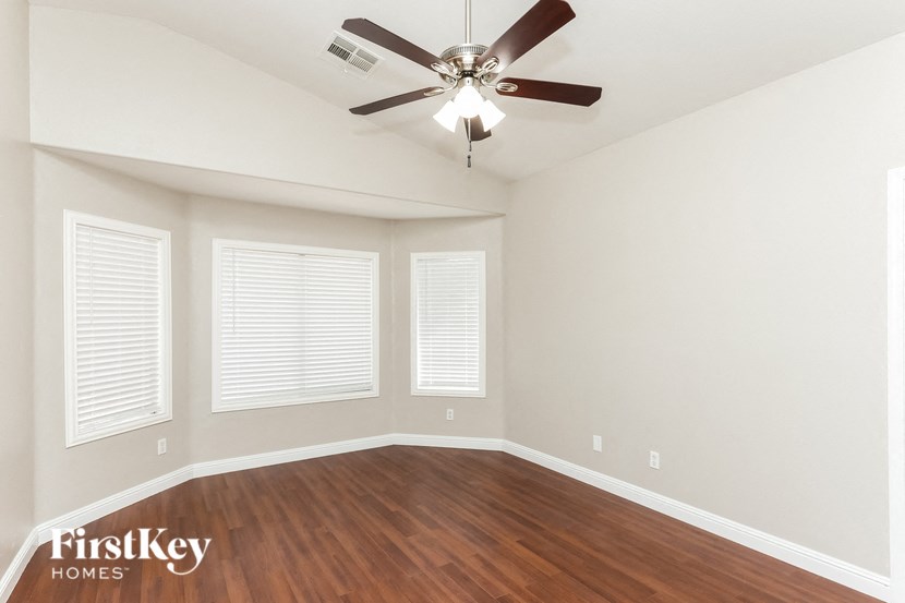 a living room with wood floors and a ceiling fan