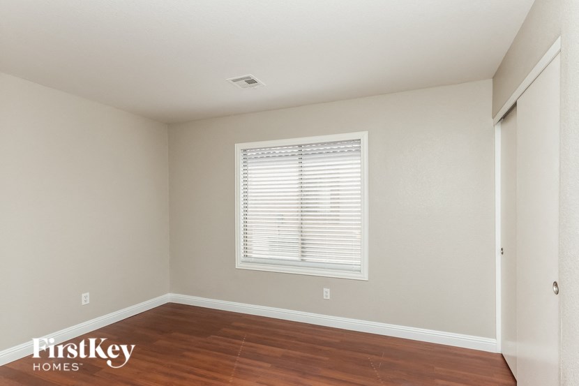 a bedroom with a window and a wooden floor and a window
