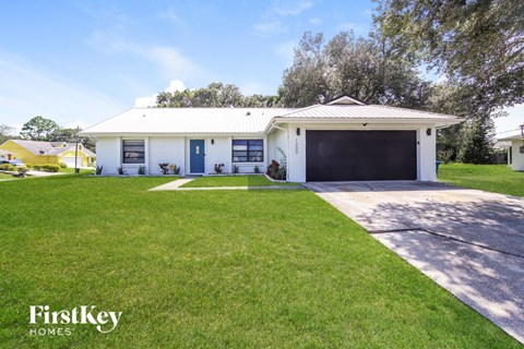 A white house with a garage is for sale.