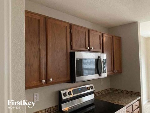 A kitchen with wooden cabinets and a stove top oven.