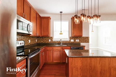 a kitchen with wooden cabinets and black counter tops and a sink