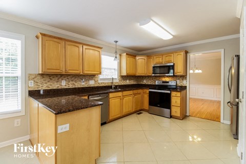 A kitchen with wooden cabinets and a granite countertop.