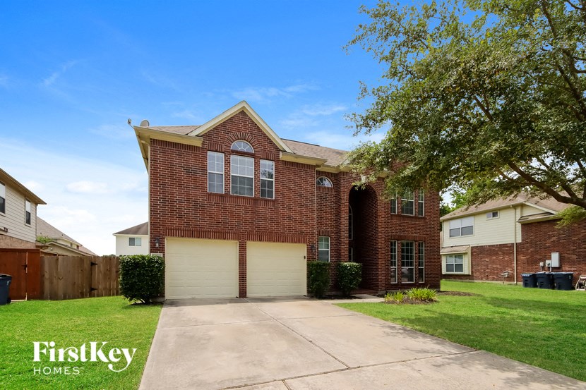 the front of a brick house with a white garage door