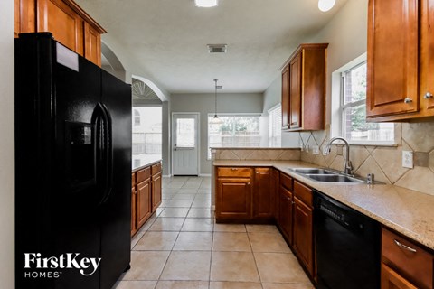 a kitchen with a black refrigerator and a sink