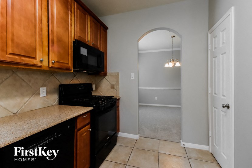 a kitchen with black appliances and wooden cabinets