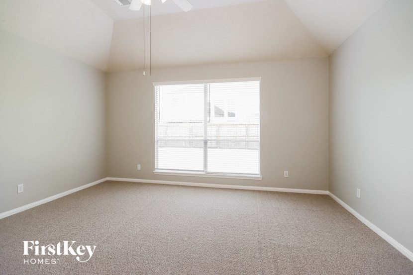 a empty room with a large window and carpet