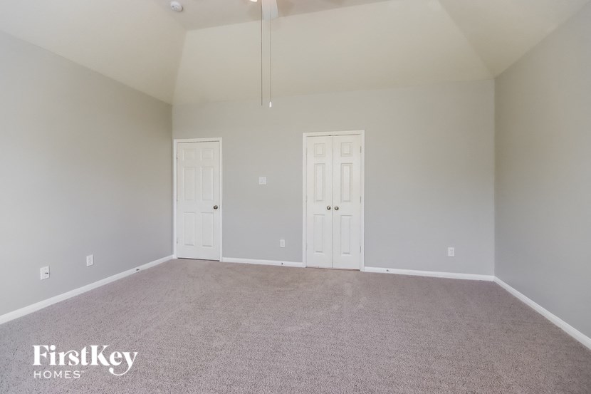 a room with carpet and two white doors