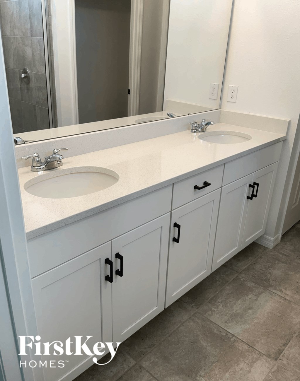 a white bathroom with two sinks and a mirror