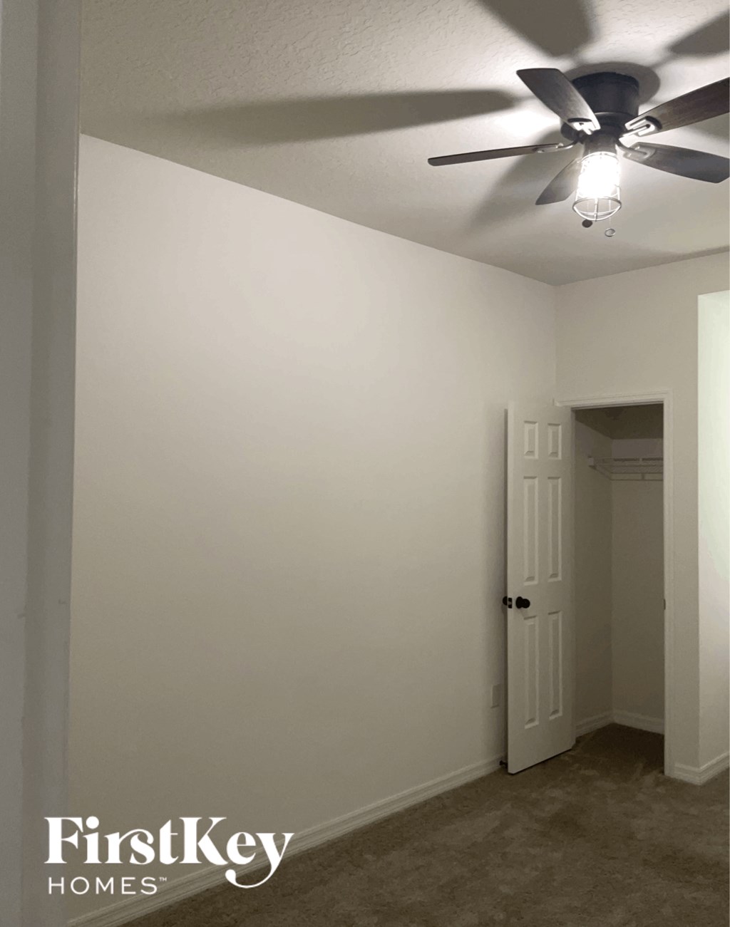 a room with a ceiling fan and a door to a closet