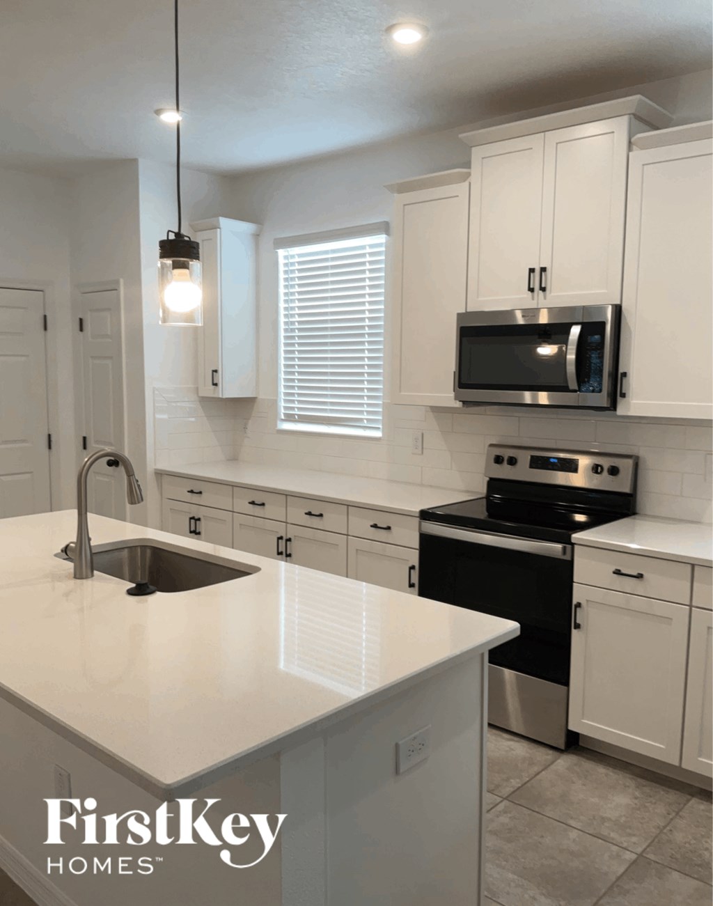 an updated kitchen with white cabinets and a white counter top