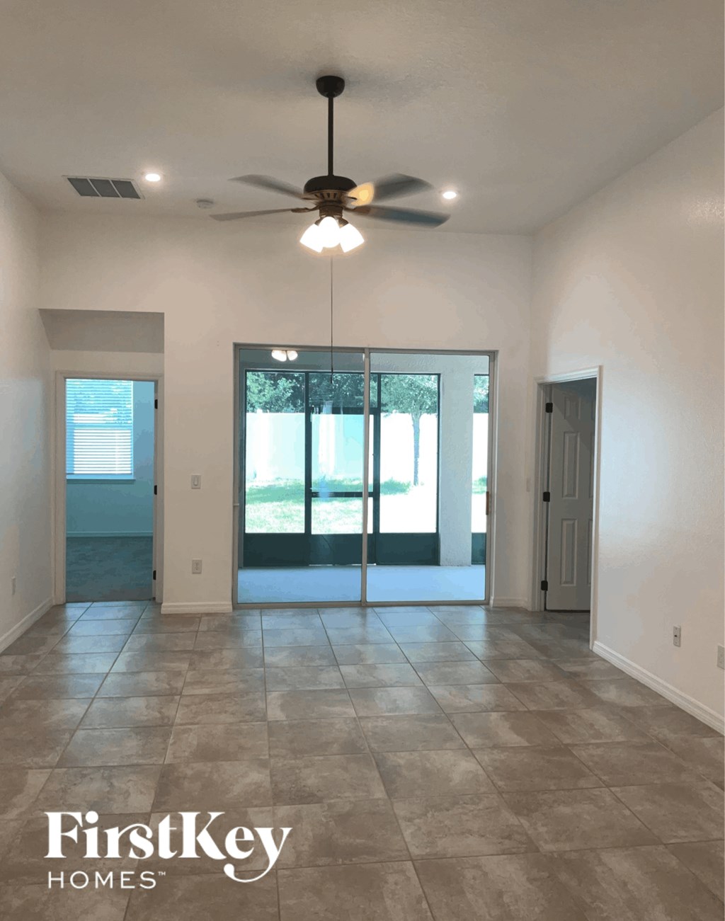 an empty living room with a ceiling fan