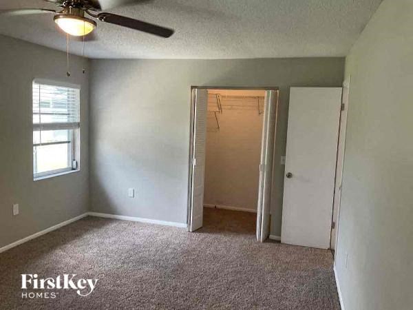 an empty bedroom with a closet and a ceiling fan