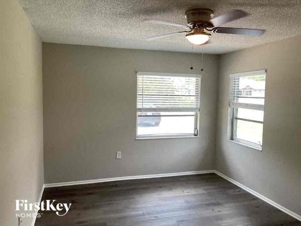 an empty room with a ceiling fan and a window
