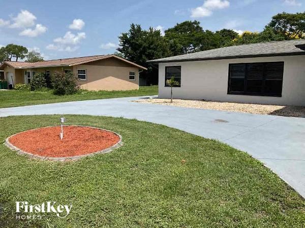 a yard with a cement driveway and a house