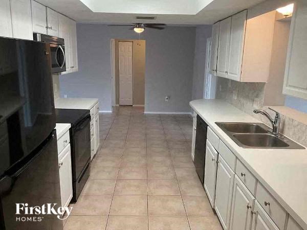 a large kitchen with white cabinets and a sink