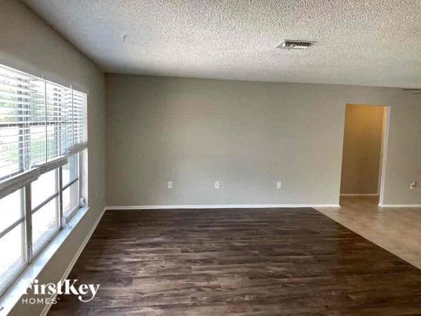an empty living room with wood floors and a window