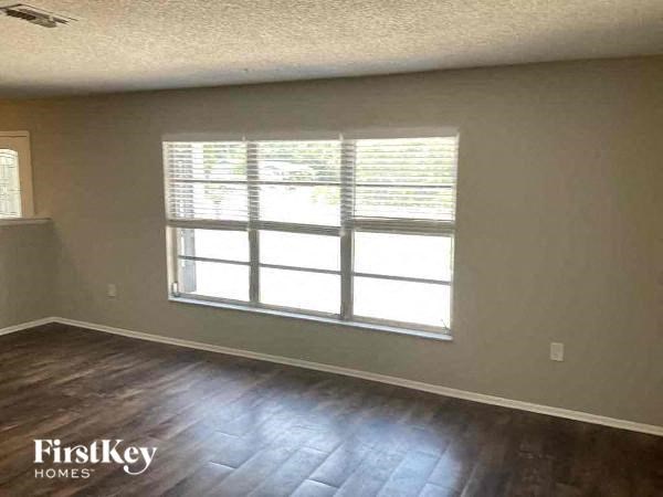 a living room with a large window and wooden floors