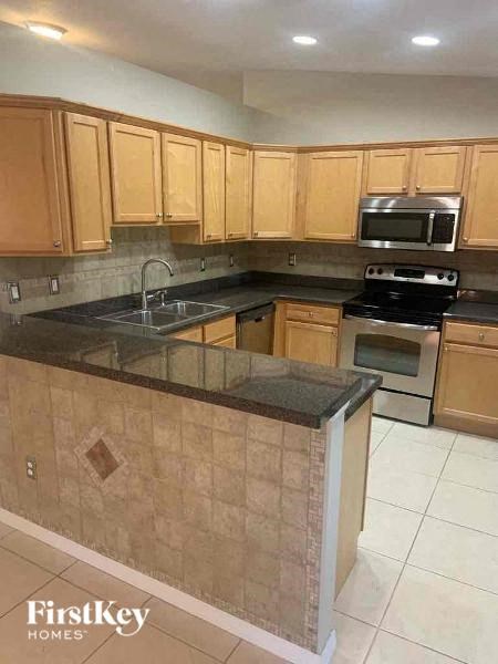 A kitchen with wooden cabinets and a black countertop.