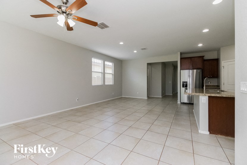 an empty kitchen and living room with a ceiling fan