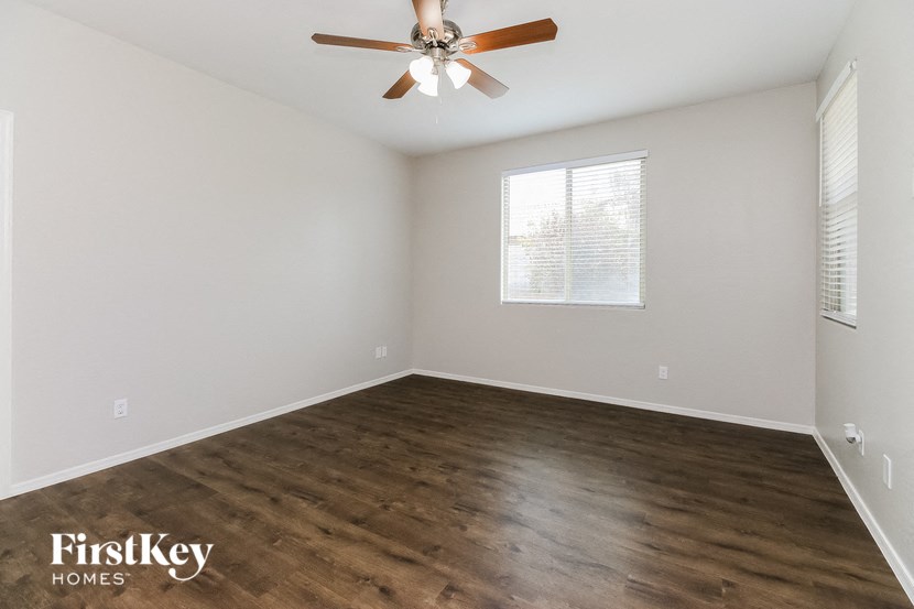 an empty room with a ceiling fan and a window