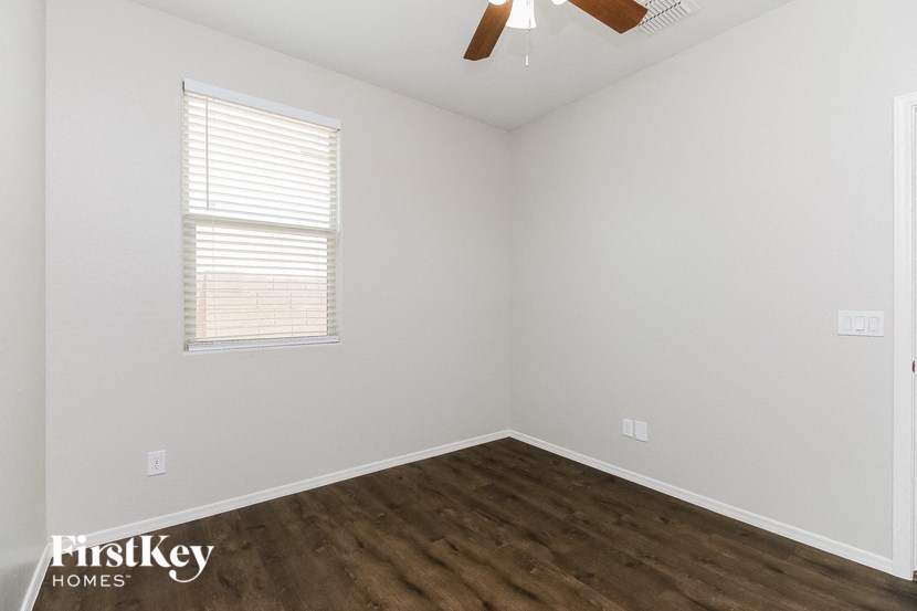 the living room of a home with wood flooring and a ceiling fan