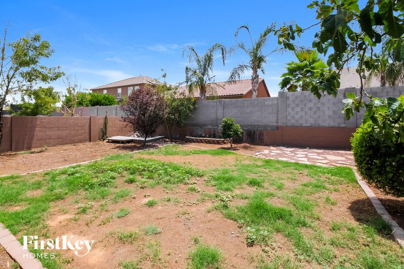 a backyard with grass and a fence and a house