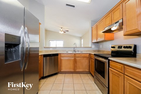 A kitchen with wooden cabinets and a stainless steel refrigerator.