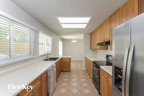 A kitchen with wooden cabinets and a stainless steel refrigerator.