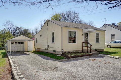 a white house with a garage and a gravel driveway