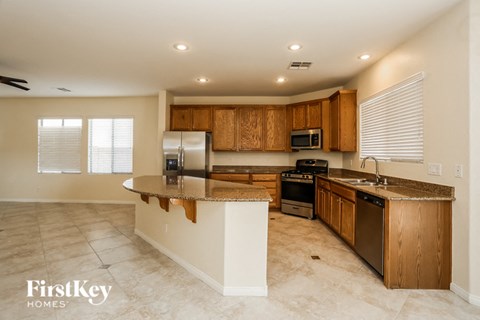 A kitchen with wooden cabinets and a marble countertop.