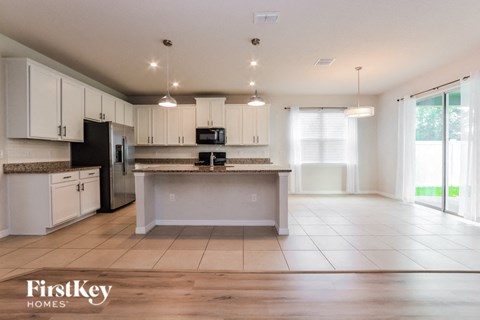 A kitchen with white cabinets and a granite countertop.