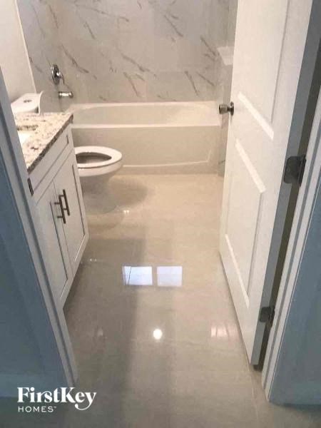 a bathroom with a toilet and a tub and a sink