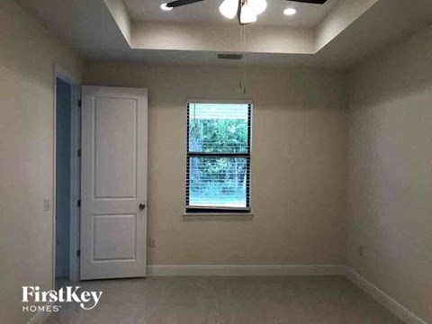 an empty room with a window and a ceiling fan