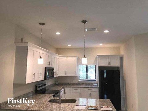 a kitchen with white cabinets and a counter top